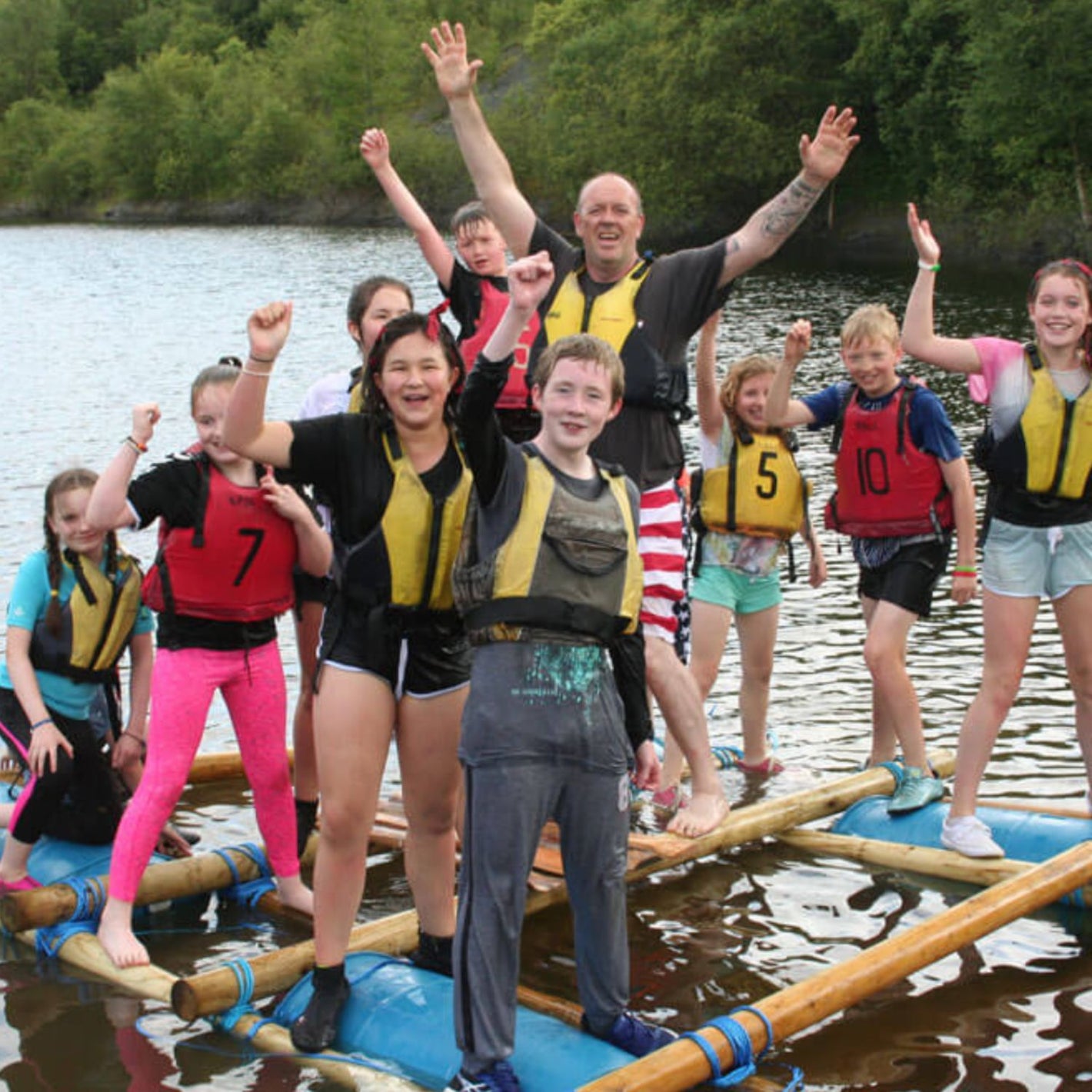group of teenagers on a raft at summer camp